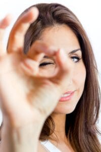 Mujer haciendo signo de "Ok" con las manos al comprobar el precio de las lentes de contacto