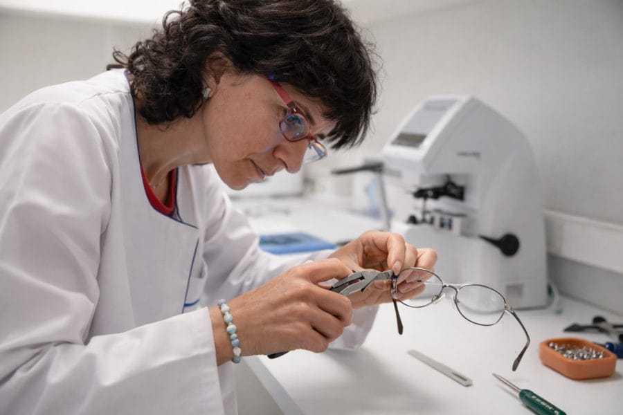 Óptico utilizando herramientas de precisión para reparar gafas